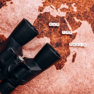 Black binoculars lies on the a geographical map
