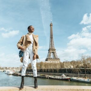 France, Paris, Smiling woman standing on a bridge with the Eiffel tower in the background