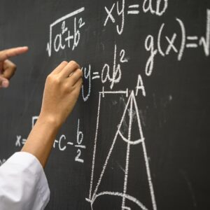 The hand that is written with the white chalk and the hand that shows the formula on the blackboard.