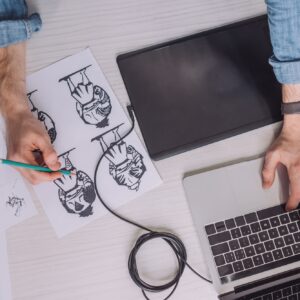 top view of illustrator drawing cartoon sketches on paper